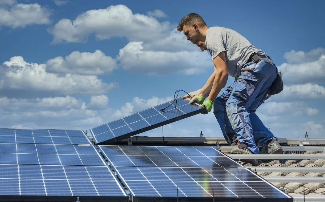 homme qui installe des panneaux solaires