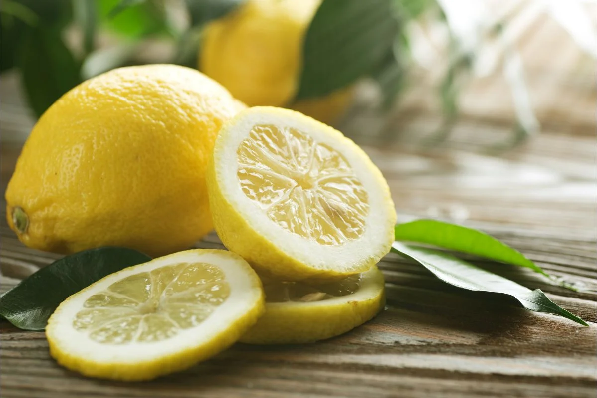 citron jeune entier, coupé en deux et en tranche à utiliser pour l'entretien de la maison