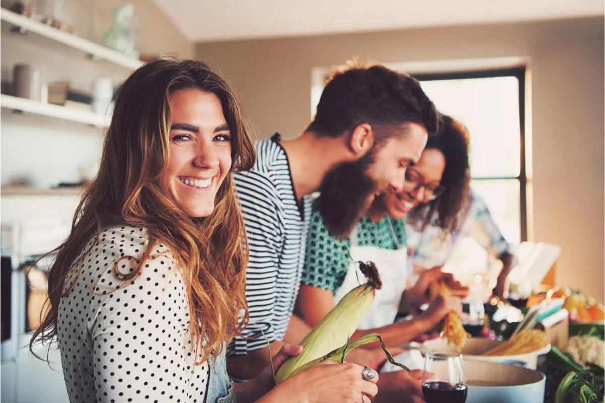 femme heureuse qui cuisine avec des amis