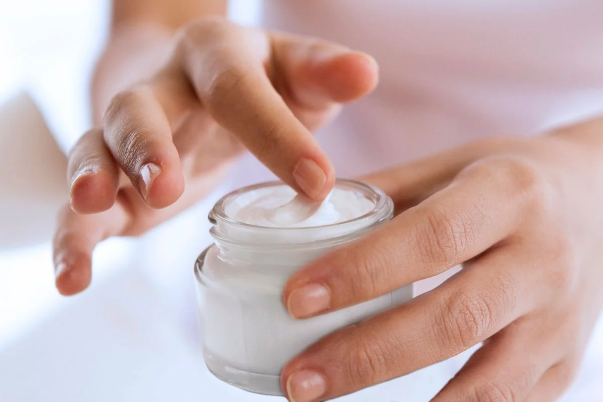 femme qui met une crème hydratante pour prendre soin de son visage