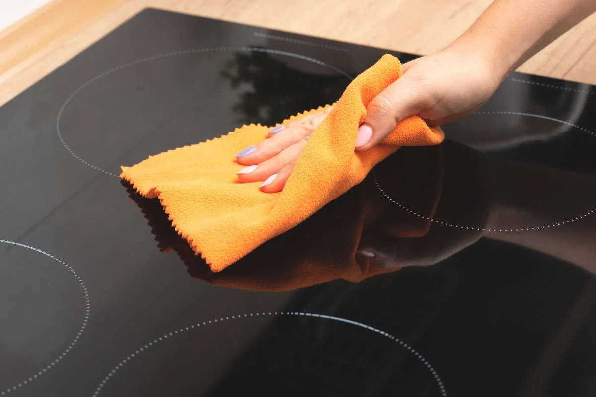 femme qui nettoie une plaque de cuisson