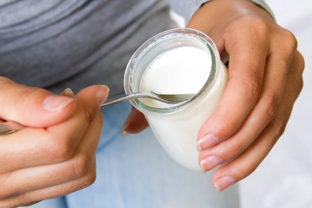 femme qui mange un yaourt source de probiotiques