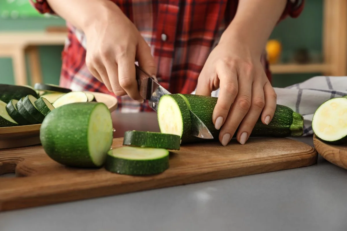 femme qui coupe des courgettes avant de les congeler