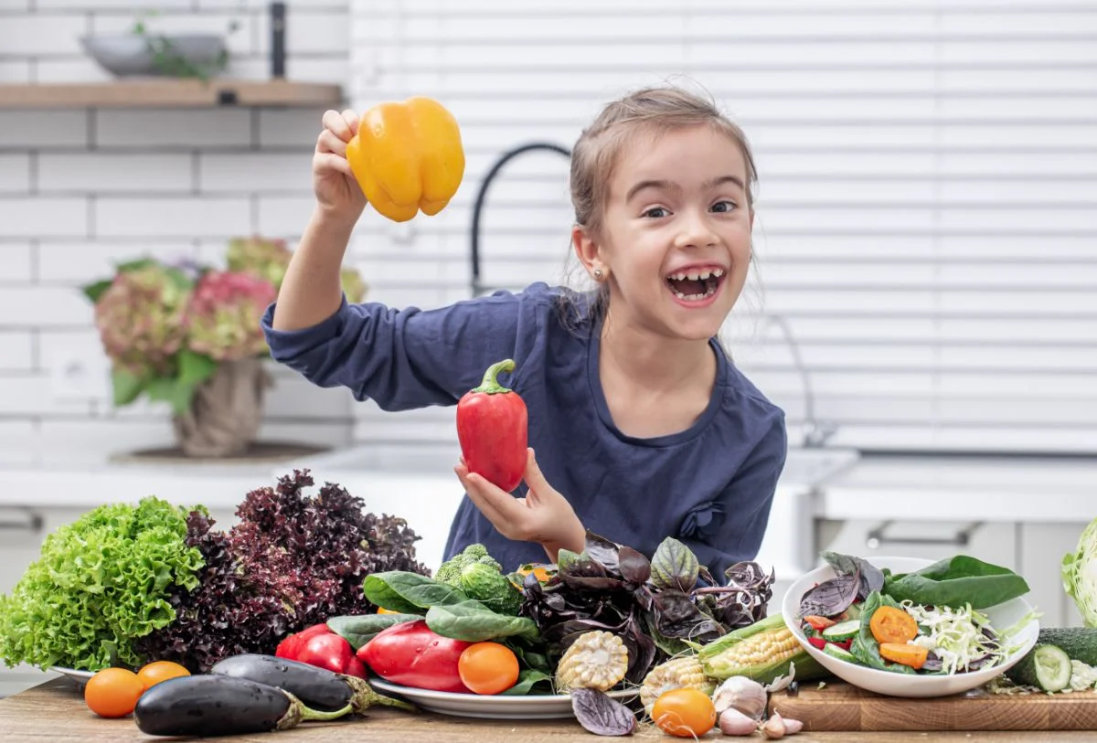 enfant dans la cuisine avec des légumes
