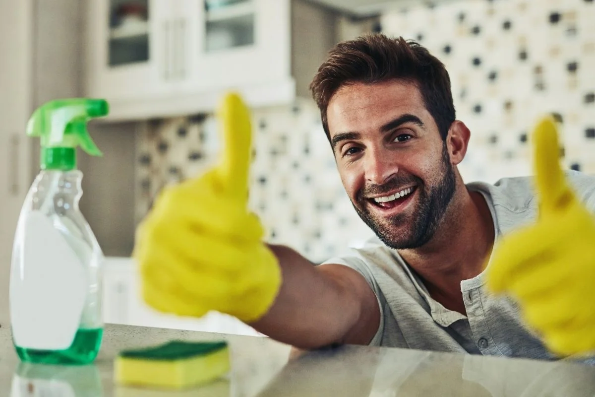 homme heureux de faire le ménage avec des produits naturels