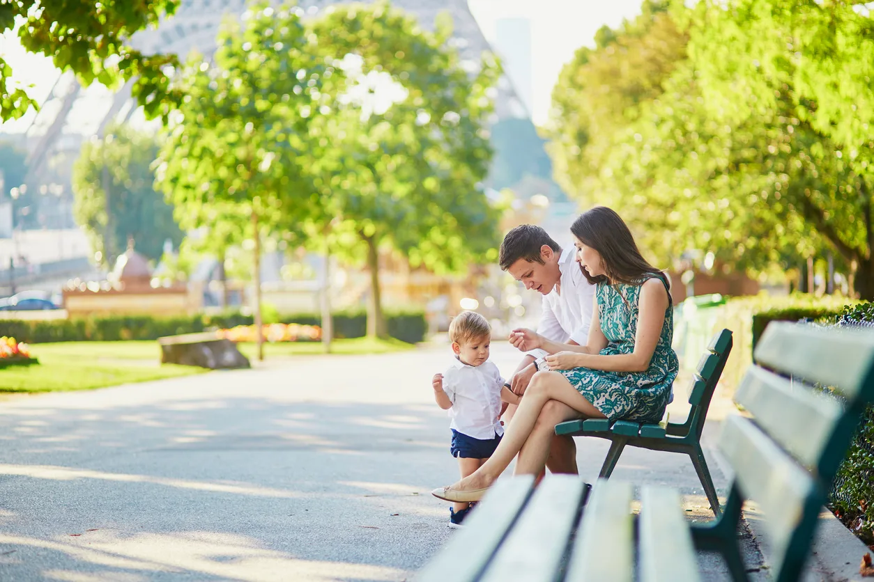 famille dans un parc assise sur un banc public